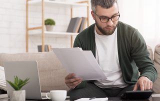 man doing calculations on sofa | HR Consultants