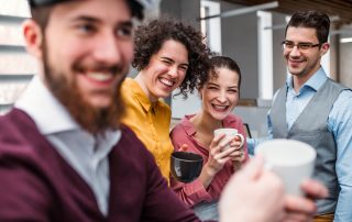 Coworkers enjoy a coffee break | Featured image for Bramwell Partners blog 'Swearing in the Workplace'.