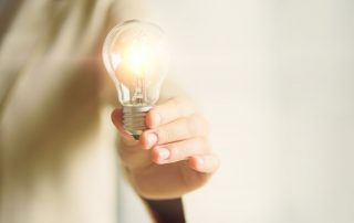 Person holding lightbulb | Featured image for HR Challenges in startups