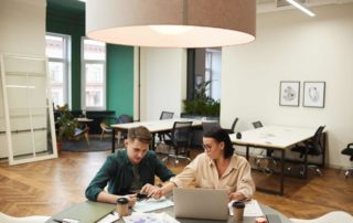 Business meeting at an office | Featured Image for the Benefits of Quality Management Systems Blog by Bramwell Partners.