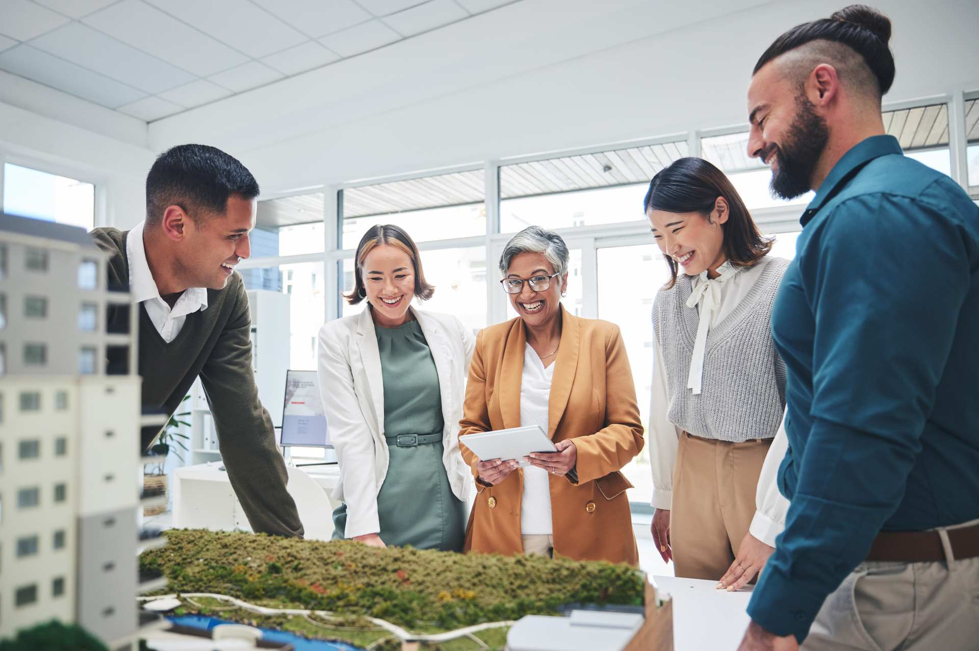 Property development team looking at a scale model | Featured image for the Environment Quality Assurance landing page from Bramwell Partners.