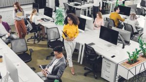 High angle view of professional young business people working with computers and papers in office.
